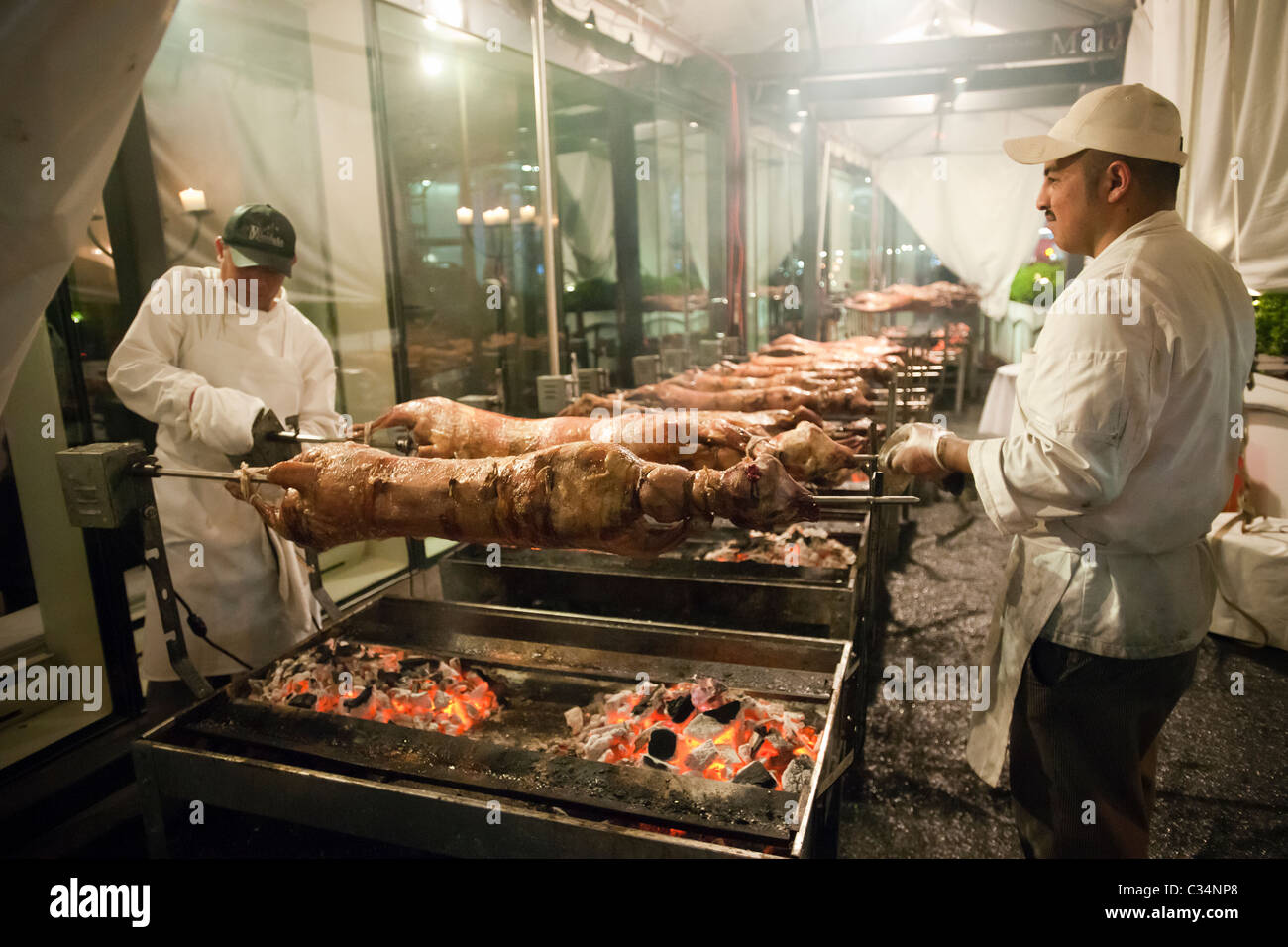 As the coals cool chefs lower the18 lambs roasting in front of a Greek