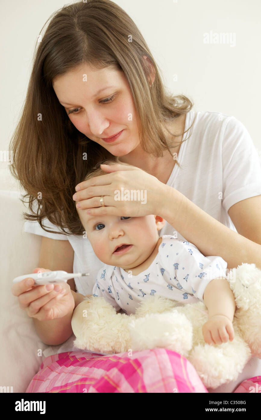Crying baby having her body temperature taken with digital thermometer