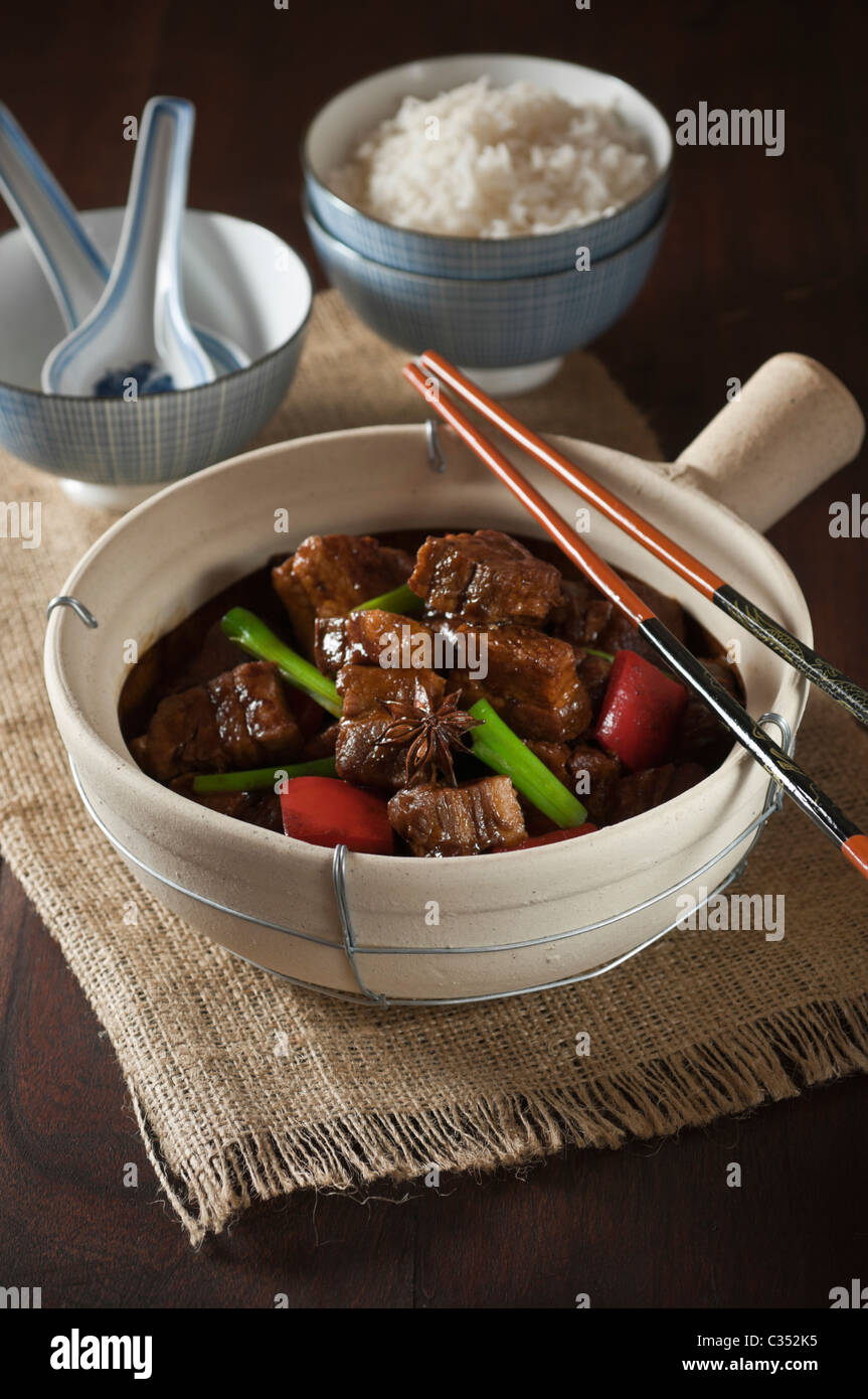 Red cooked pork belly in traditional clay pot. Chinese food Stock Photo