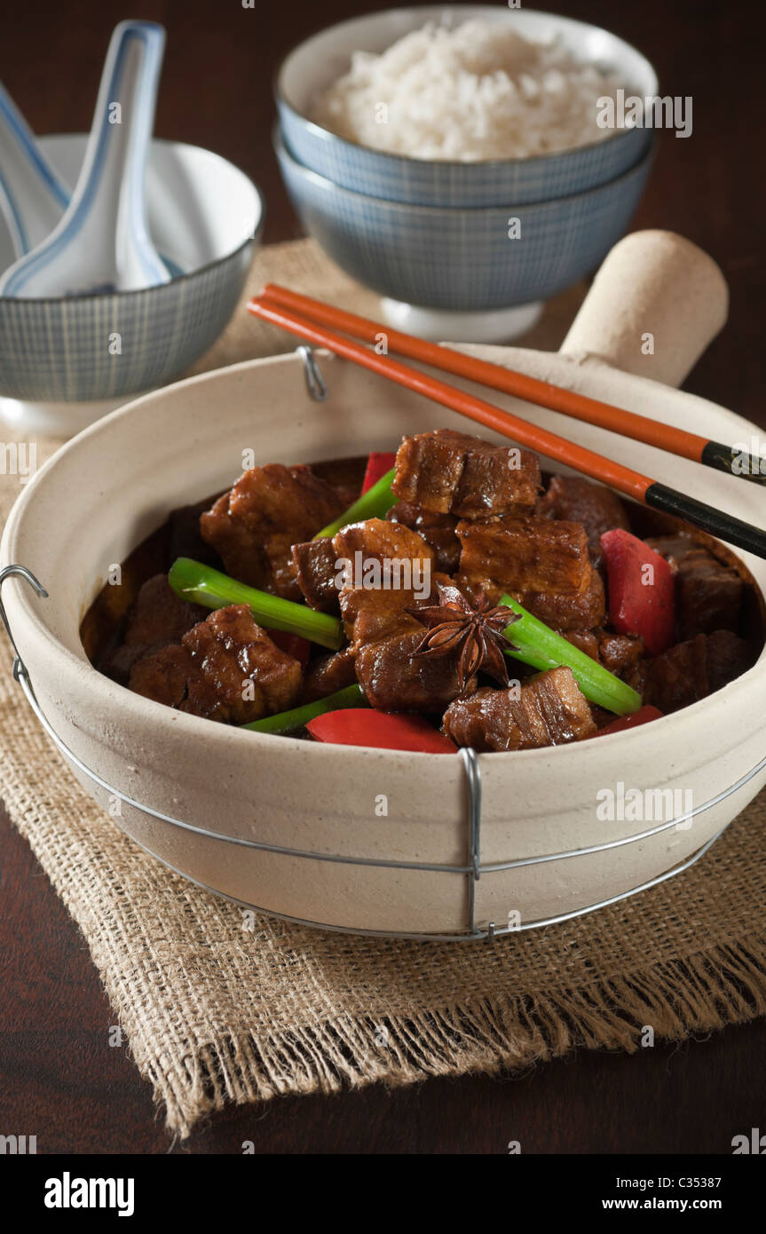 Red cooked pork belly in traditional clay pot. Chinese food Stock Photo