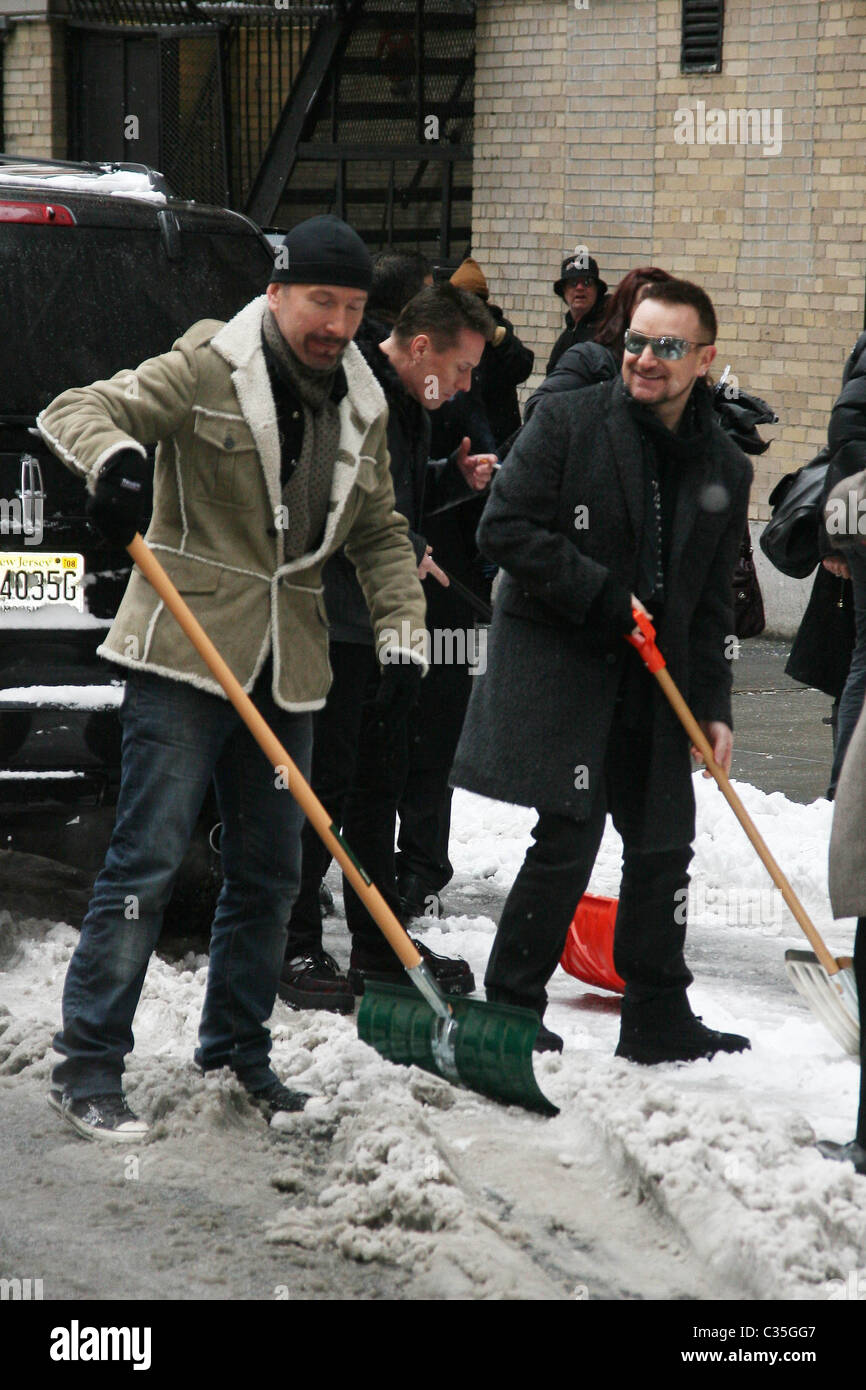 The Edge, Bono and Larry Mullen, Jr. of U2 shovel snow outside the Ed Sullivan Theater for 'The Late Show with David Letterman' Stock Photo
