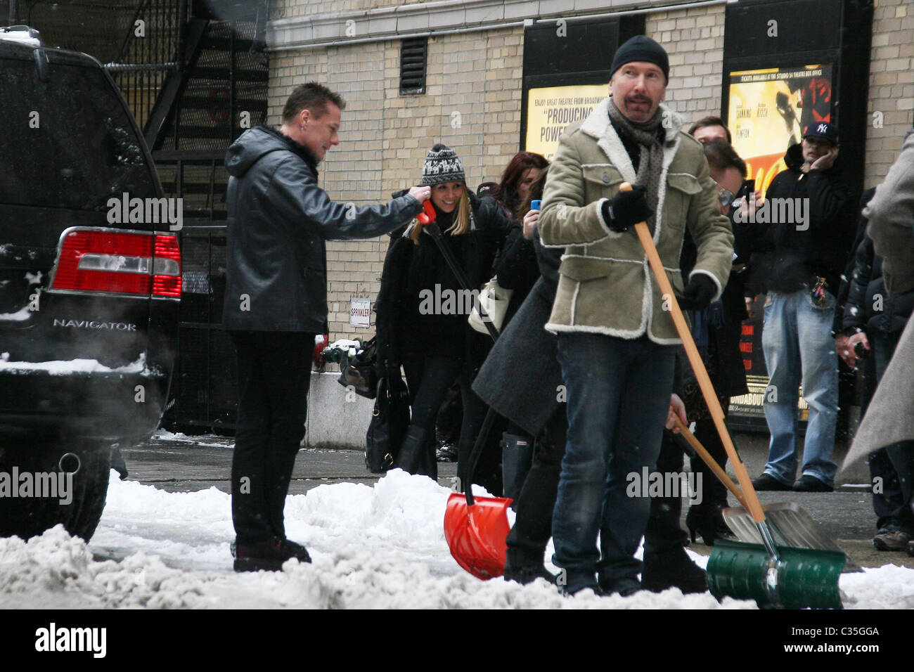 The Edge, Bono and Larry Mullen, Jr. of U2 shovel snow outside the Ed Sullivan Theater for 'The Late Show with David Letterman' Stock Photo