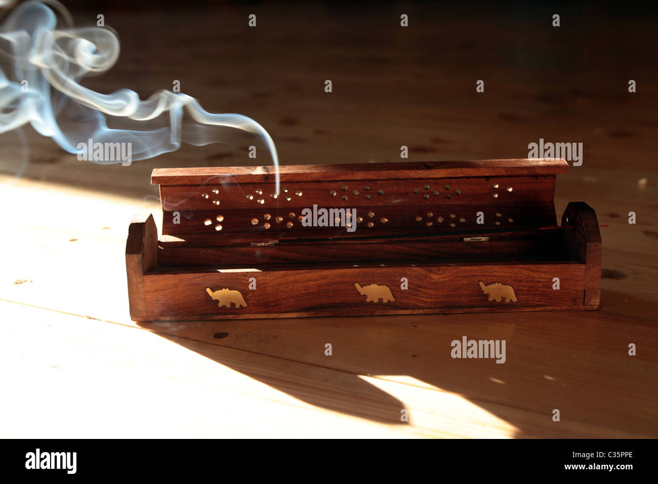 Incense sticks wooden holder with incense stick burning inside it Stock