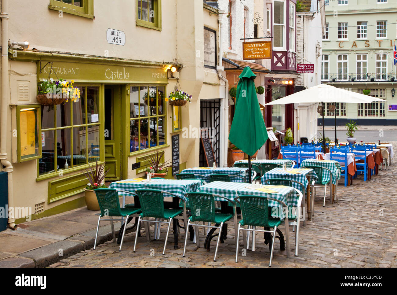 Tables and chairs outside a wine bar and restaurant in Church Lane, a small cobbled street in Windsor, Berkshire, England, UK Stock Photo