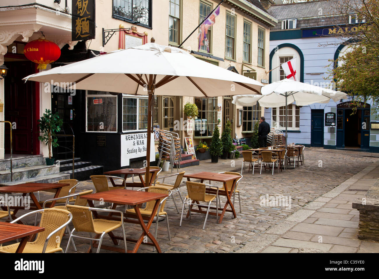 Tables and chairs outside restaurants in Church Street, a small cobbled street in Windsor, Berkshire, England, UK Stock Photo