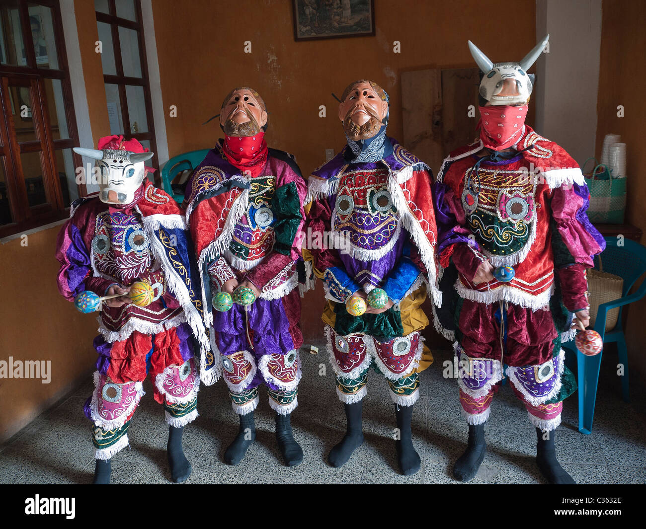 Four male Mayan dancers in their traditional dancing costumes at Habitat for Humanity meeting in Totonicapan, Guatemala. Stock Photo