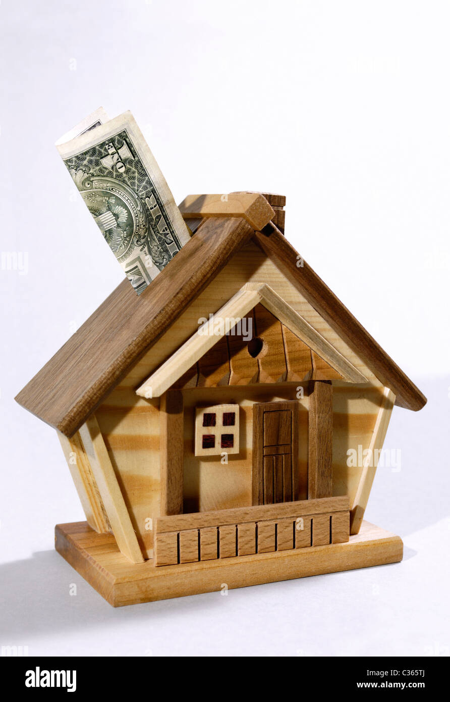 Dollar bill being deposited into a house money box. Investment, real estate, mortgage concept