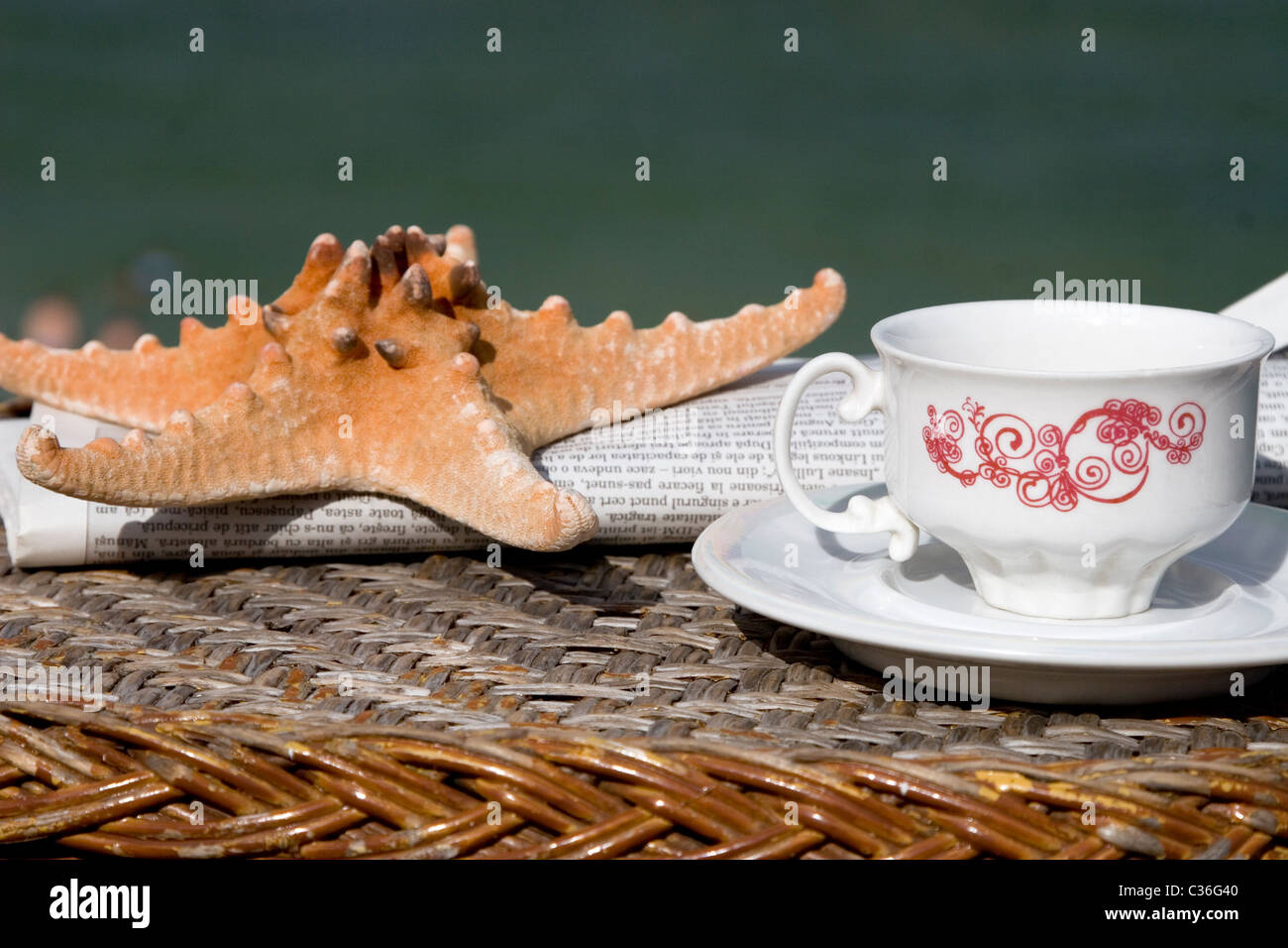 coffee cup, newspaper and starfish on wooden table Stock Photo
