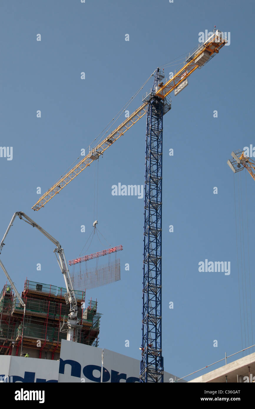 Tower crane lifting a prefabricated reinforcement bar cage used for concrete frame construction in Stratford, East London, UK. Stock Photo