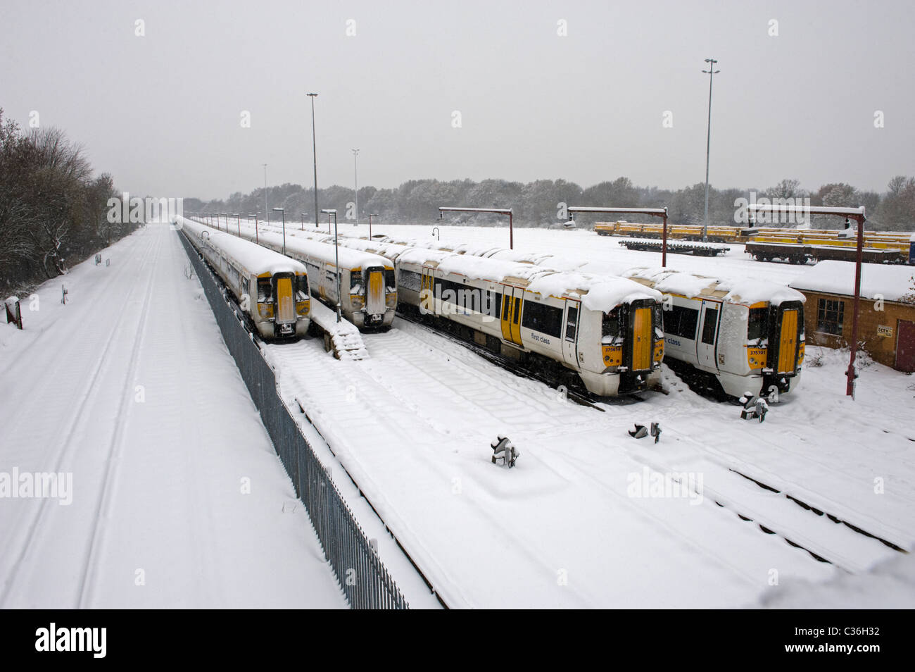 Snow Covered Railway Tracks and Stationary Trains Seen in Falling Snow
