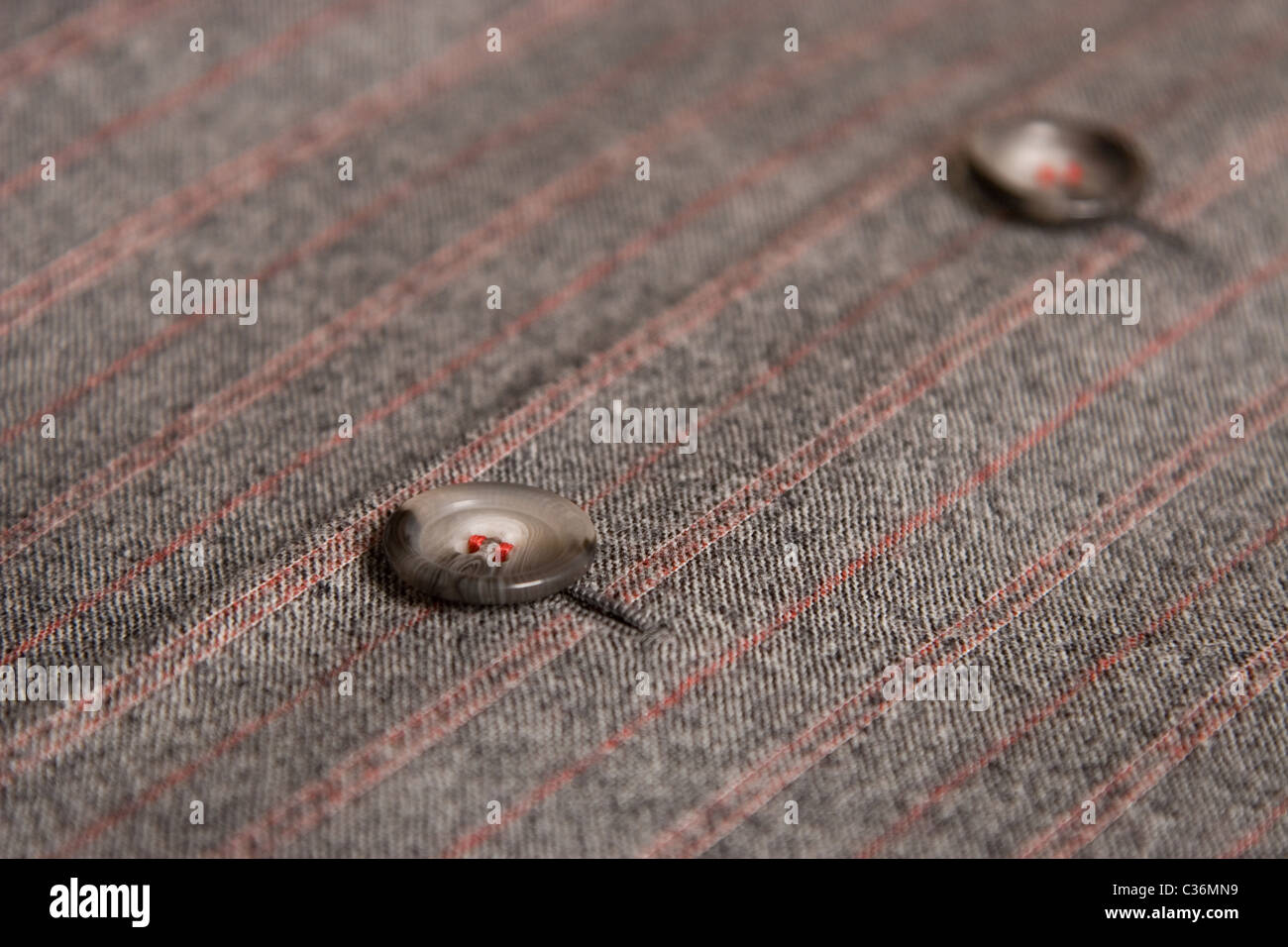 two buttons from classic coat and red thread Stock Photo - Alamy