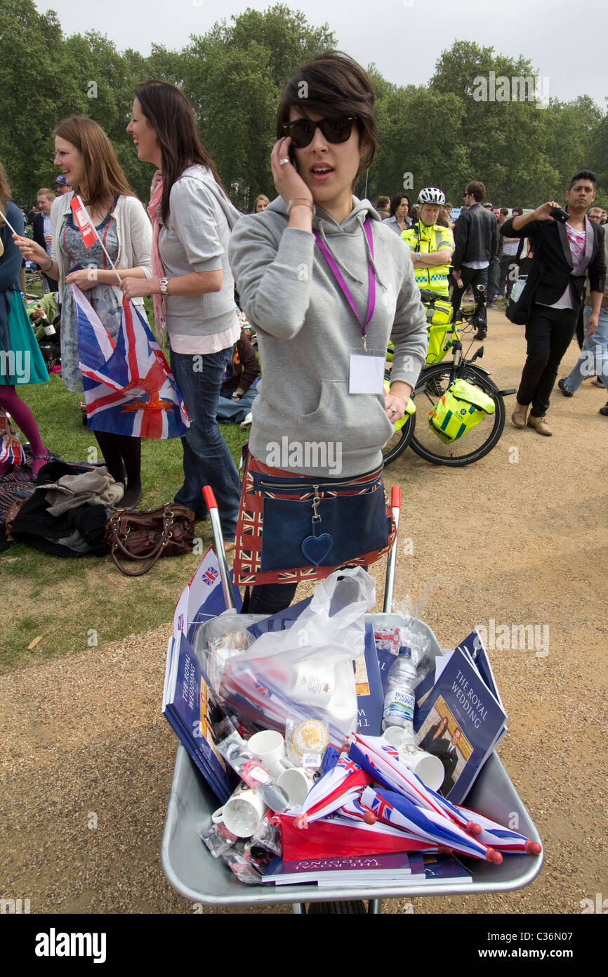 Royal wedding vendor on phone with wheelbarrow selling programmes and wedding ephemera, Hyde Park, London, UK Stock Photo