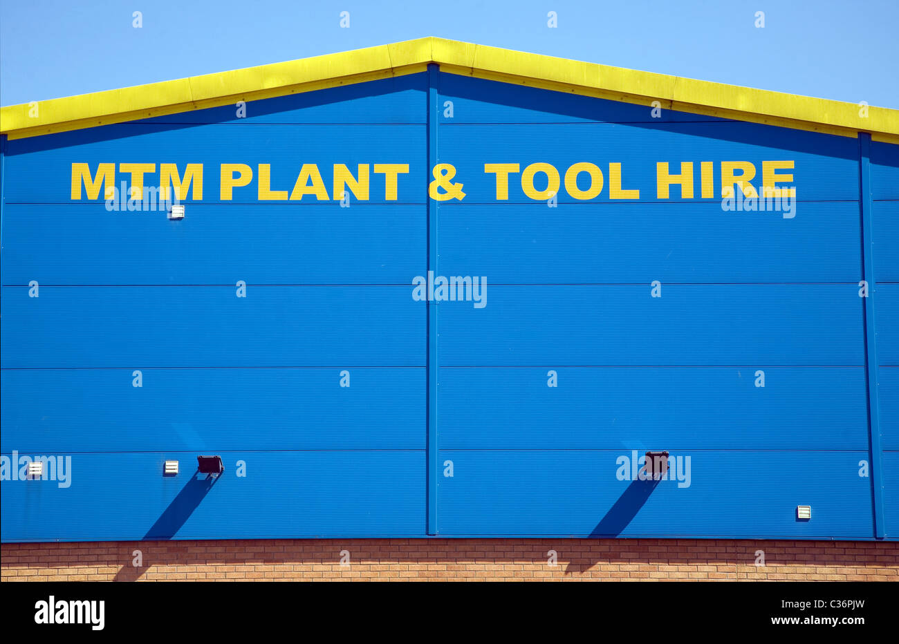 Yellow and blue graphic design pattern on industrial building MTM Plant and Tool Hire company Sudbury Suffolk England Stock Photo