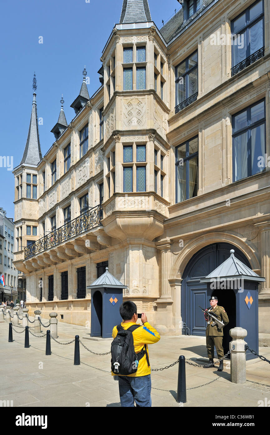 Tourist taking picture of guard in front of the Grand Ducal Palace / Palais grand-ducal at Luxembourg, Grand Duchy of Luxembourg Stock Photo