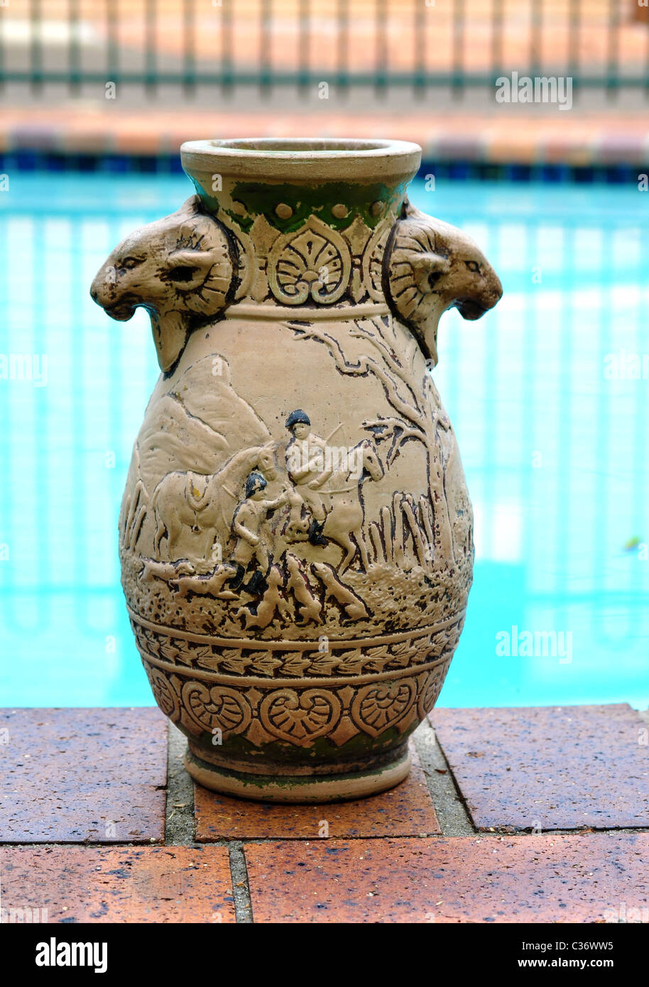 Antic vase is standing on the side of the pool. Stock Photo