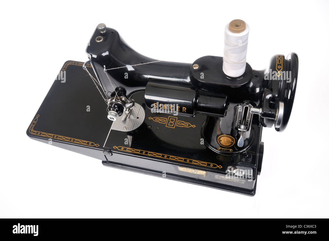 Vintage Singer sewing machine threaded with spool of white thread on white background,  cutout. Stock Photo