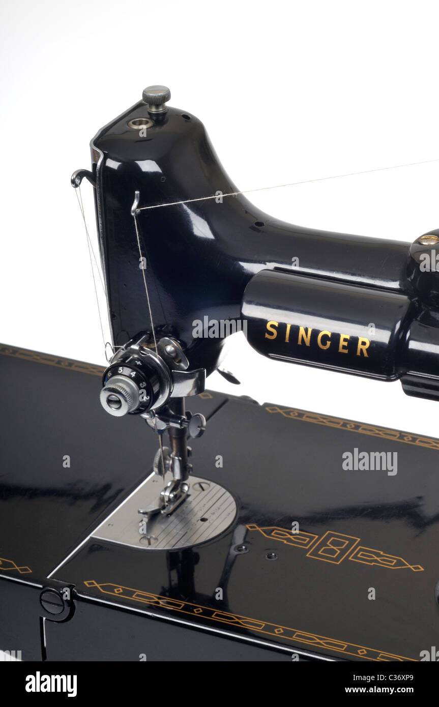 Vintage Singer sewing machine threaded with spool of white thread on white Stock Photo