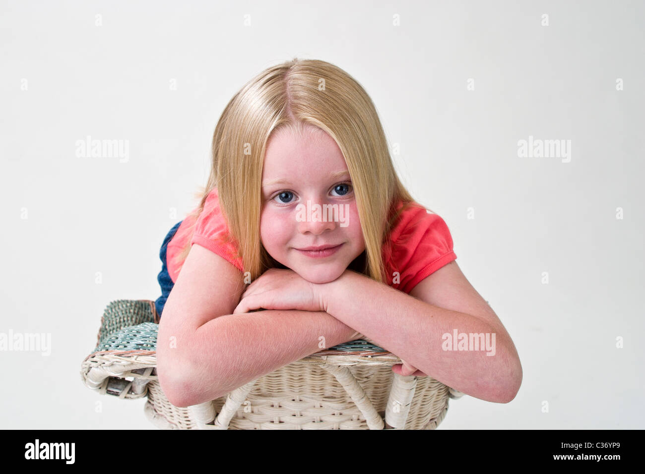 portrait of a 5-6 year old girl leans on the back of chair on her arms. MR © Myrleen Pearson Stock Photo