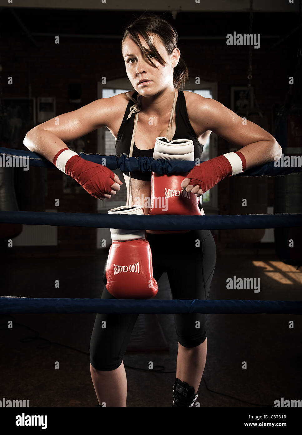 Female boxer posing at edge of ring Stock Photo