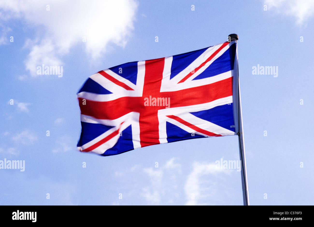 Union Jack Flag British national flags flagpole pole poles UK flying in wind flagstaff England UK English Red white and blue Stock Photo