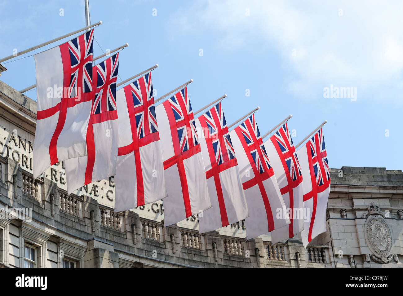 A view looking up at a row of white ensign flags flying over Admiralty Arch in London Stock Photo