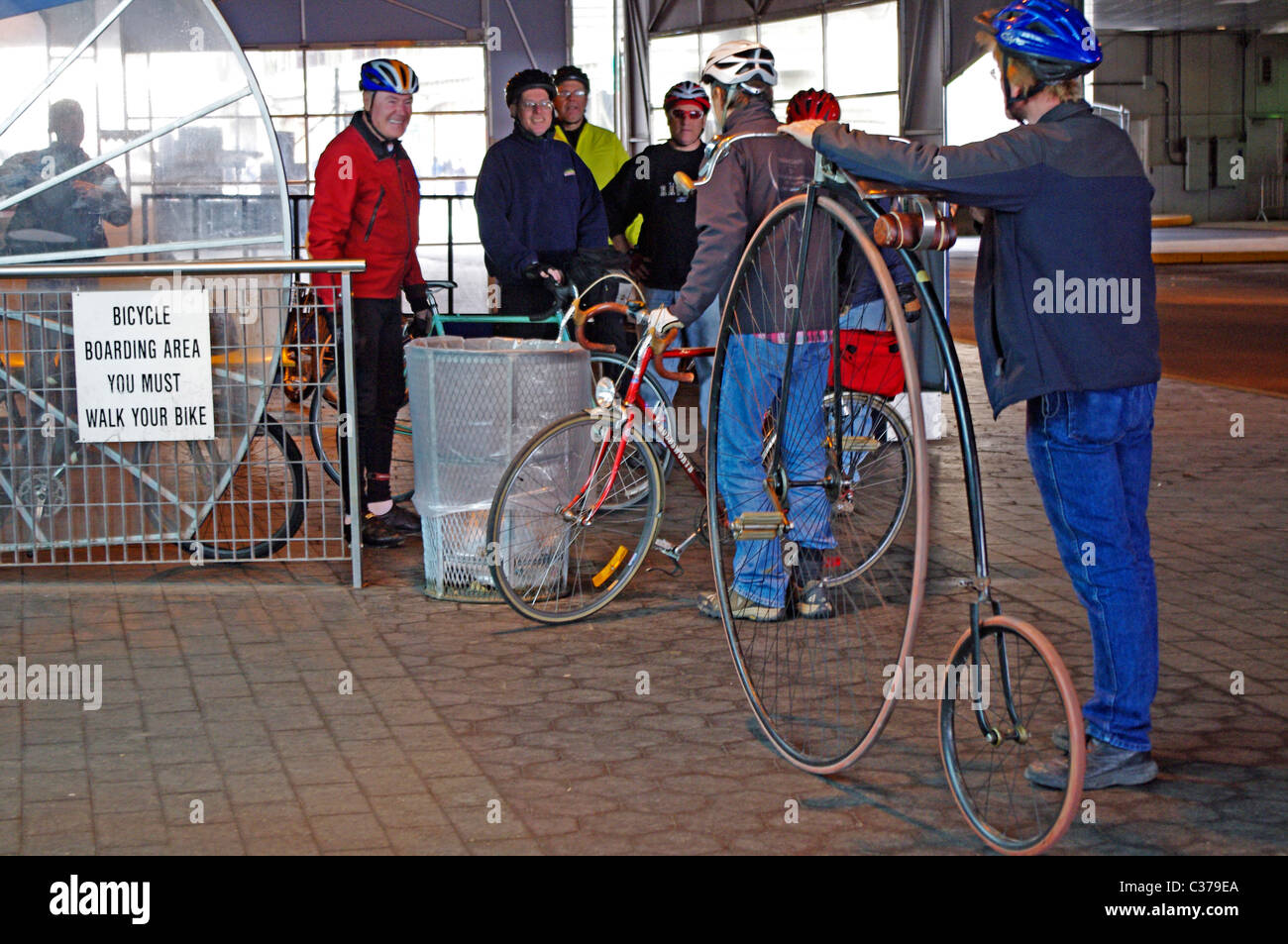 Rider of antique high-wheel bicycle at loading area of Staten Island Ferry, Manhattan, NYC Stock Photo