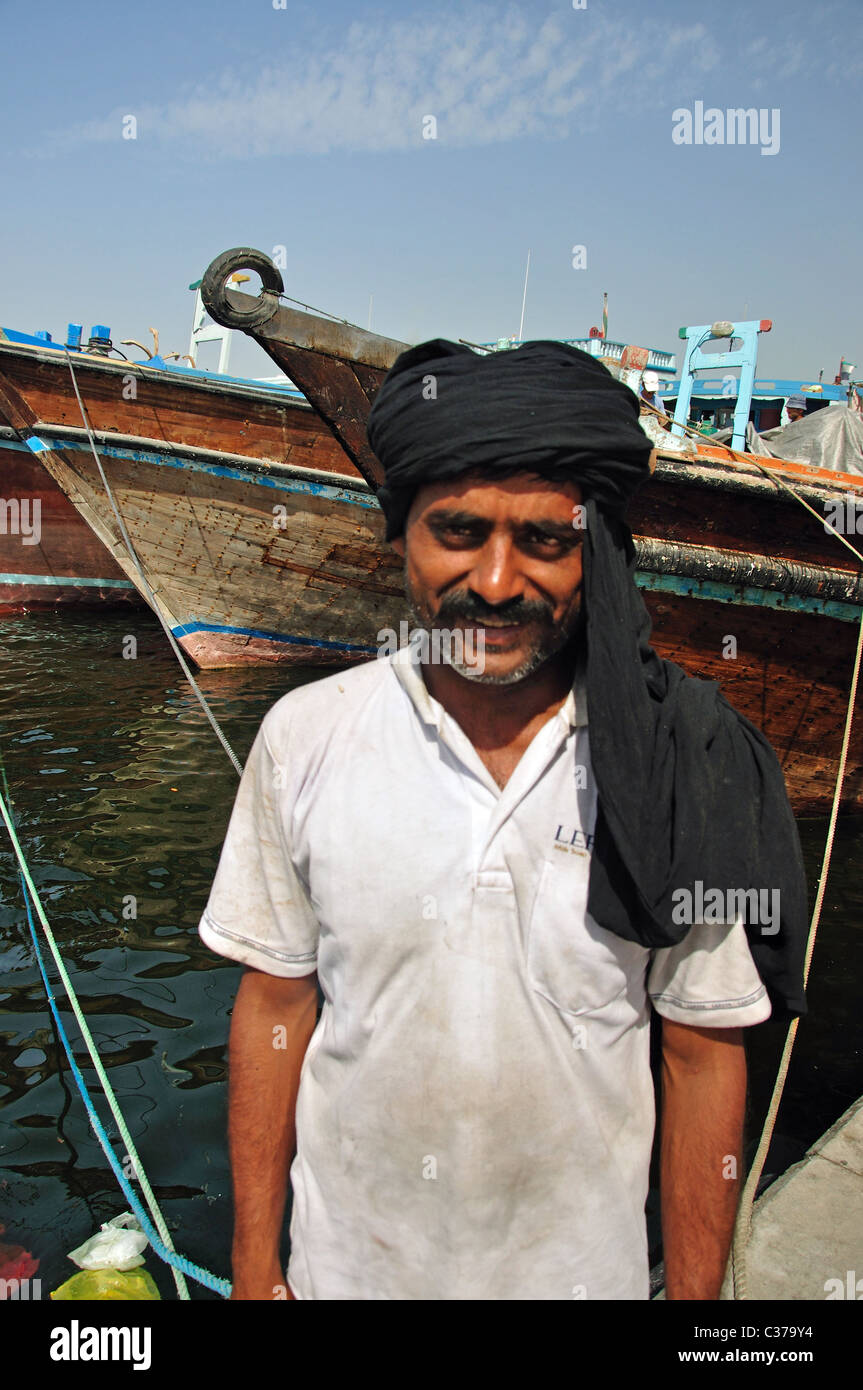 Dhow worker on quay, Dubai Creek, Deira, Dubai, United Arab Emirates Stock Photo