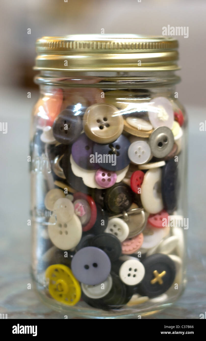 A jar of buttons against a blurry background Stock Photo Alamy