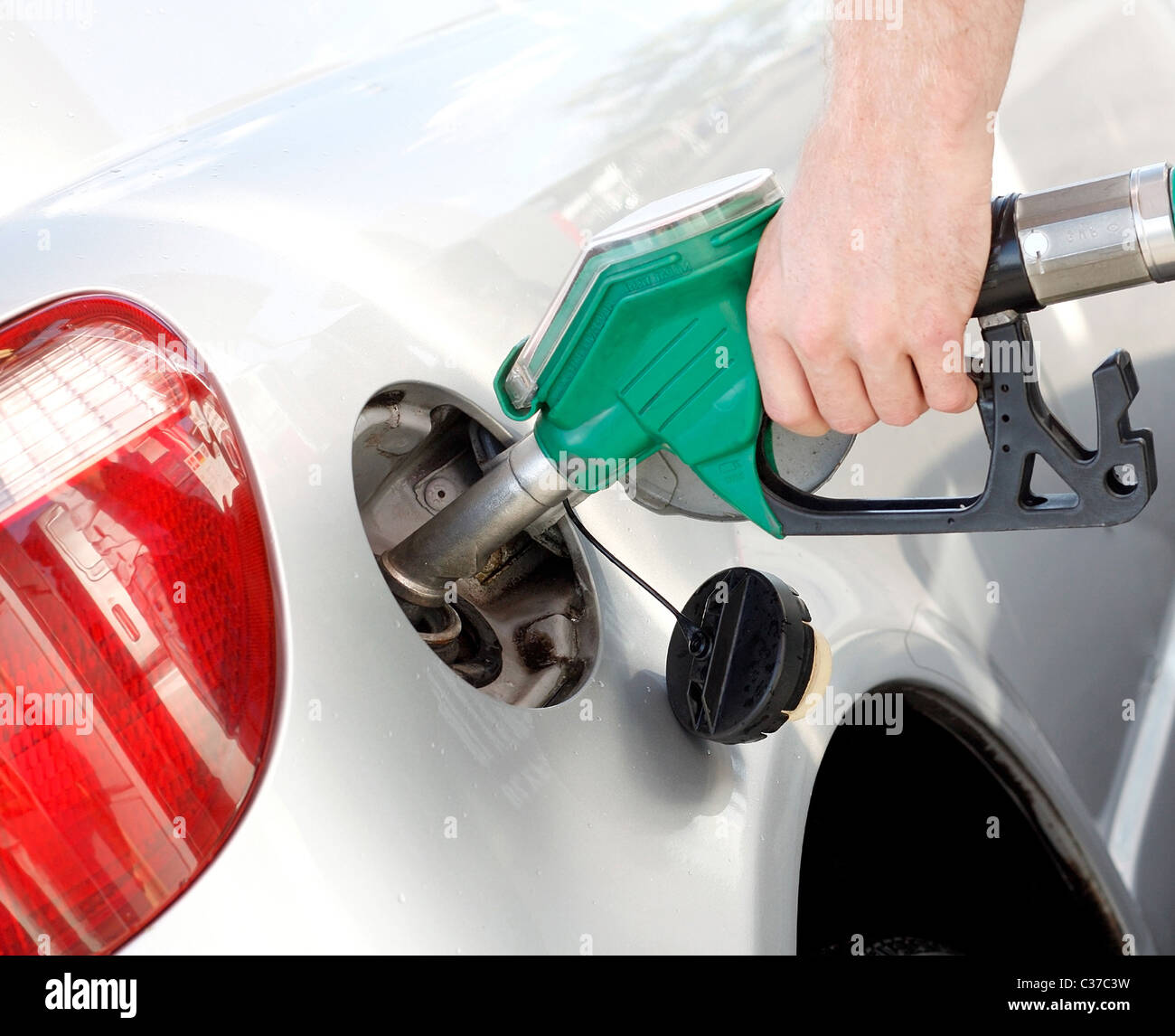 A man pumping gas in to the tank Stock Photo