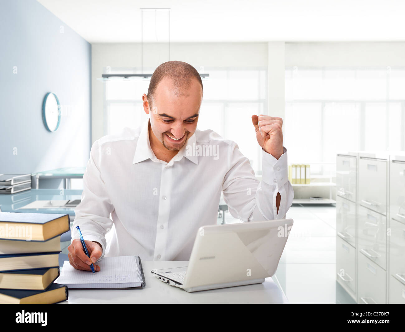 happy man with white laptop in modern office Stock Photo