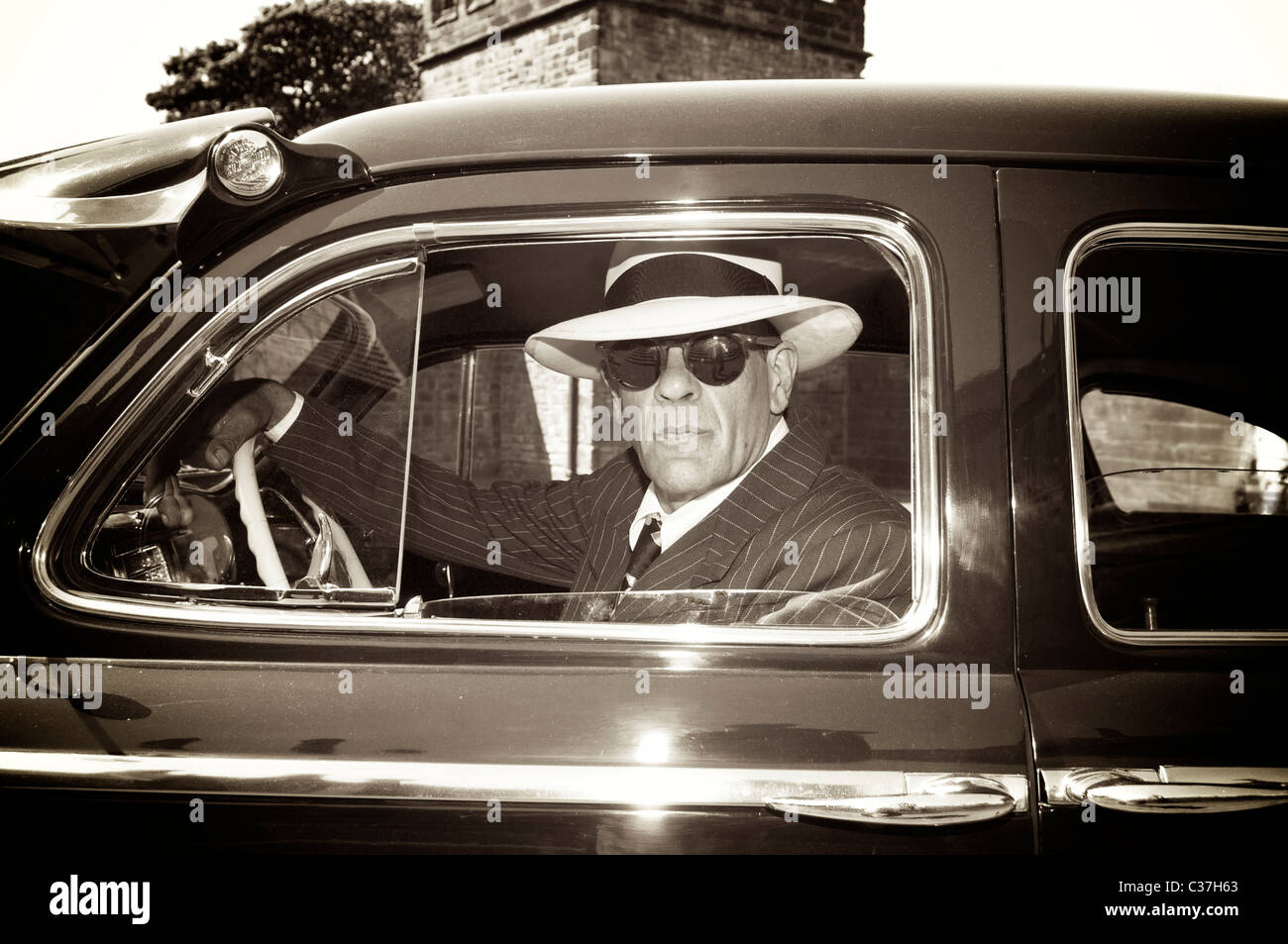 1940s style US government agent in 1942 Chrysler New Yorker car Stock Photo