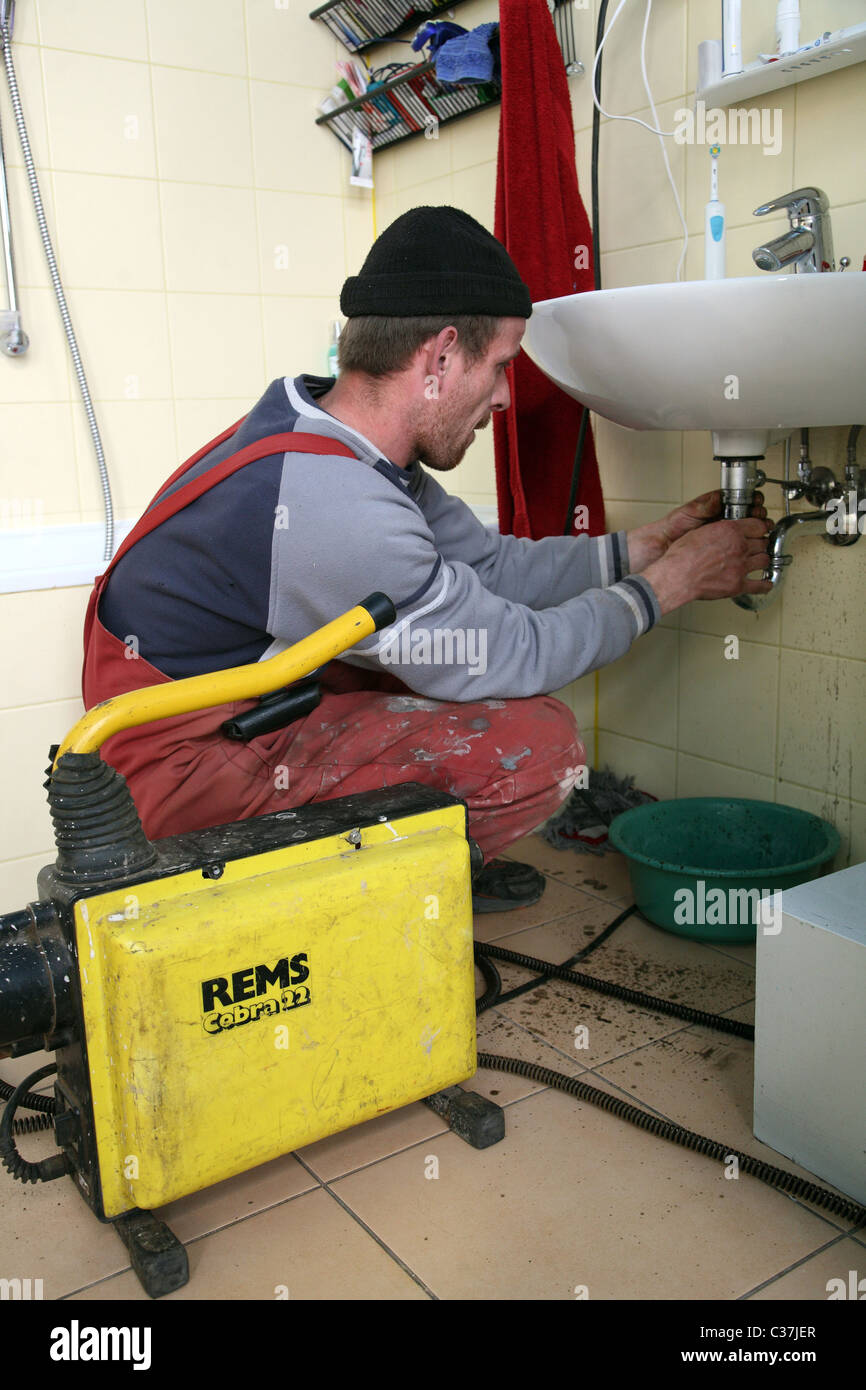 A plumber clearing a clogged drain Stock Photo