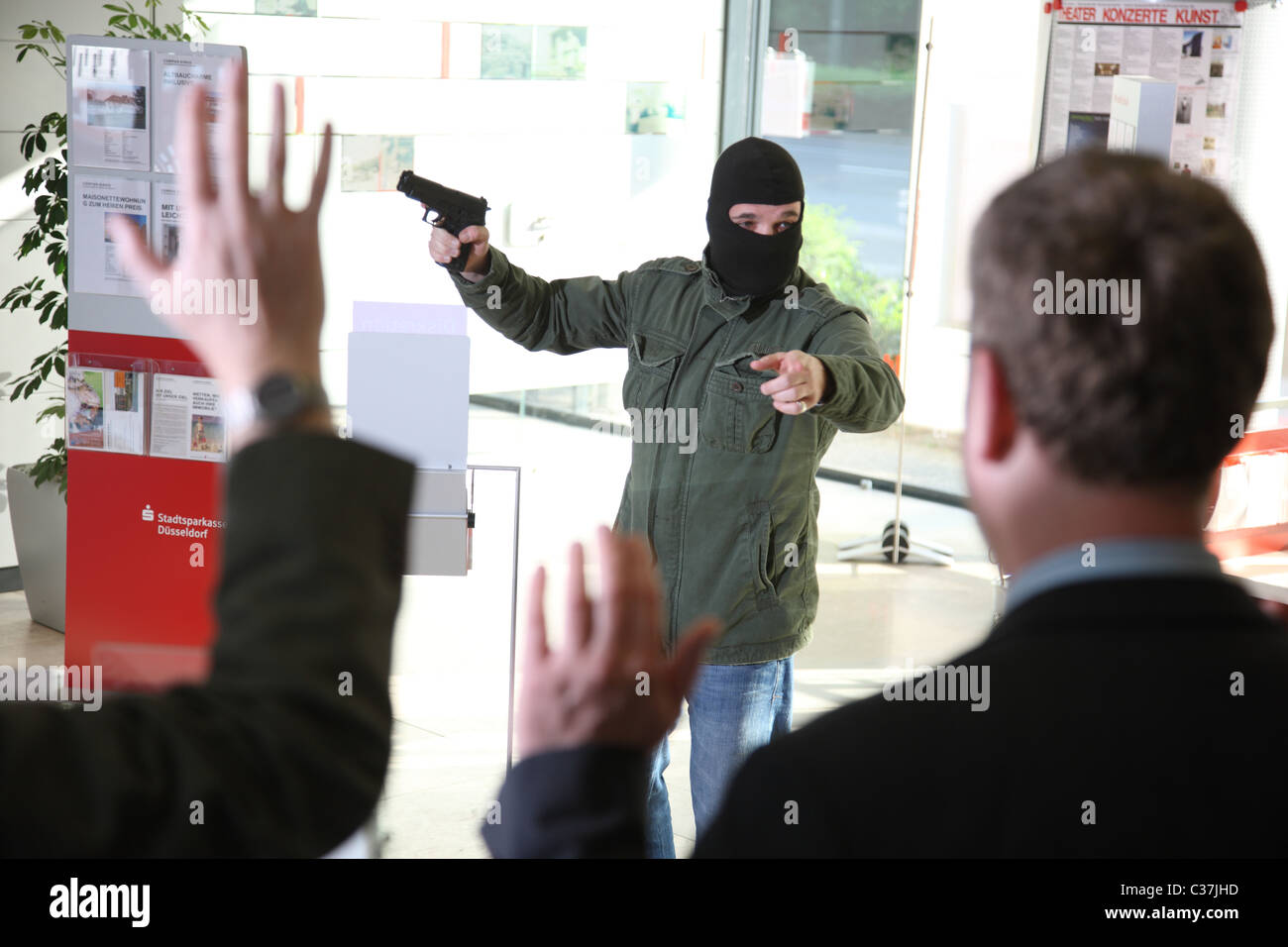 Police exercise. Bank robbery. Bank robber with a gun takes hostages in a bank. Stock Photo