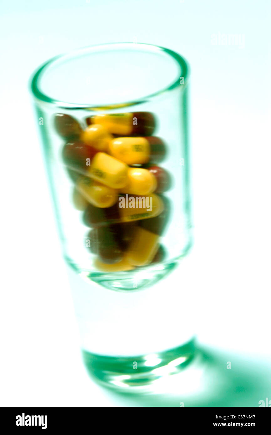 Medicine tablets and pills in shot glass close up Stock Photo