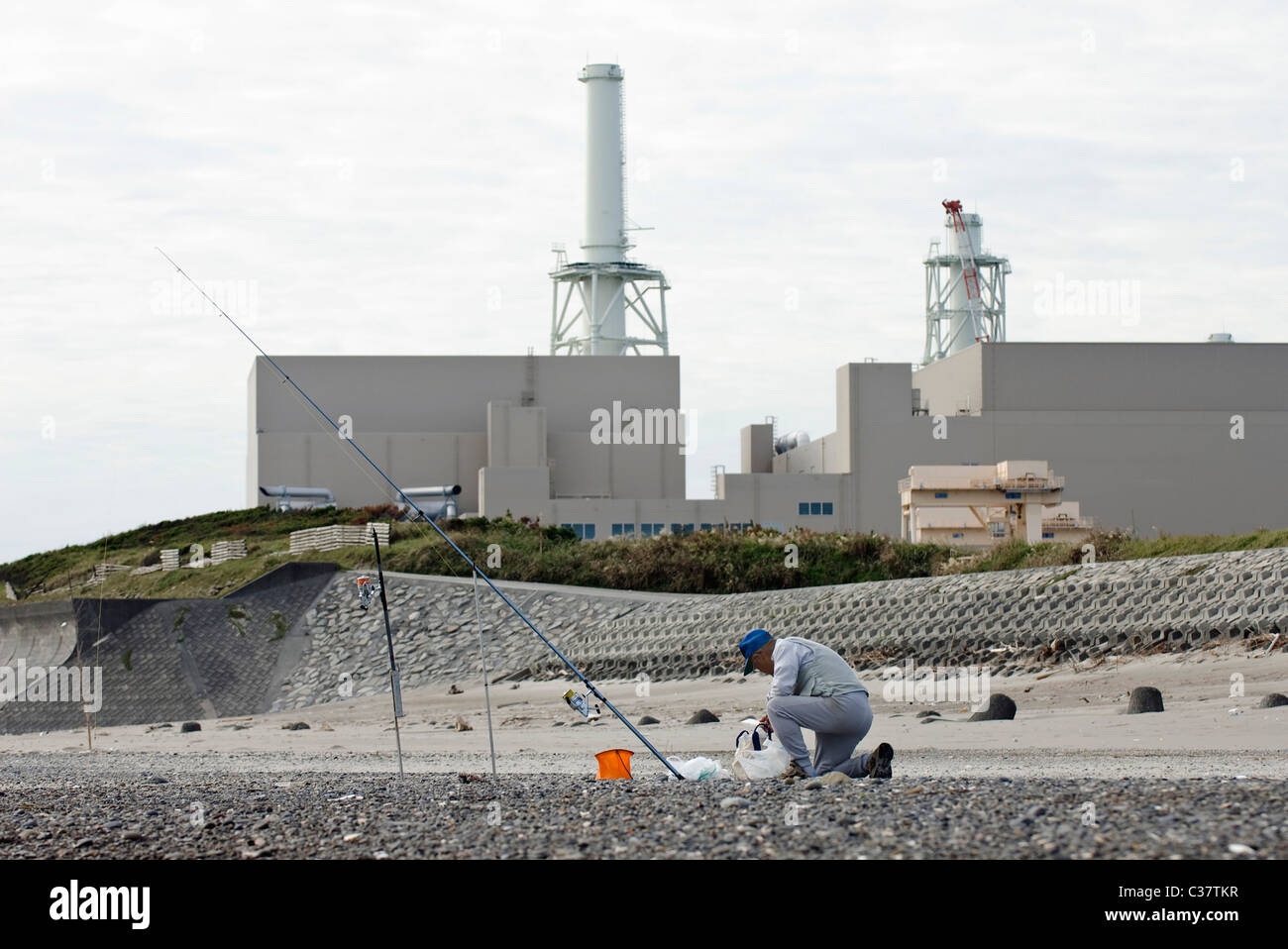 A Man Fishes From The Beach In Front Of Hamaoka Nuclear Power Plant Stock Photo Alamy