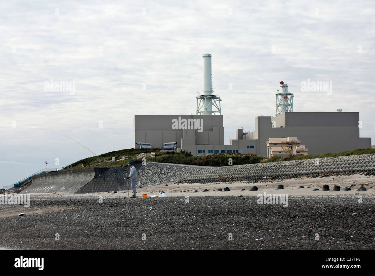 A Man Fishes From The Beach In Front Of Hamaoka Nuclear Power Plant Stock Photo Alamy
