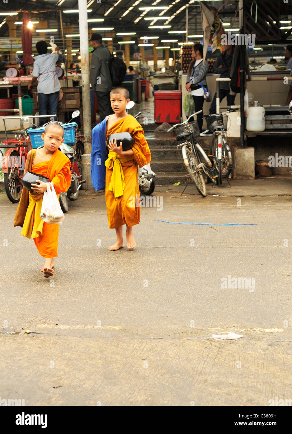 Novices on their early morning alms round , street scene , mae sot market, mae sot, thailand Stock Photo