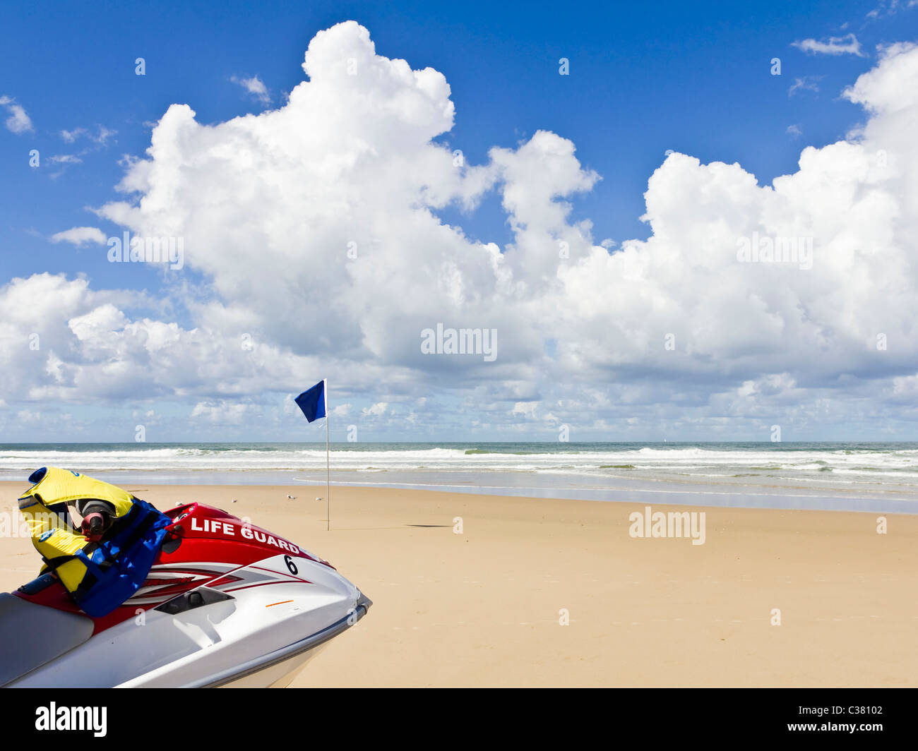 Beach lifeguard rescue boat on sand with waves and gathering storm Stock Photo