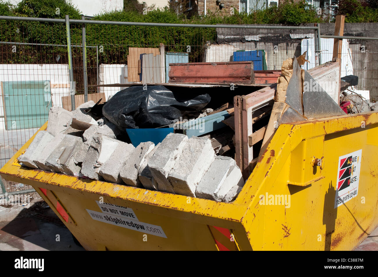 A builders skip full of old building materials Stock Photo