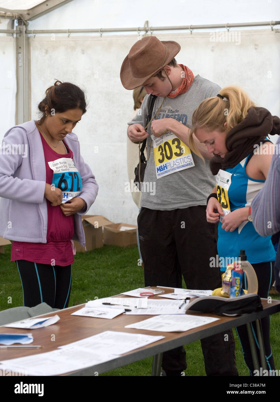 pinning on race number before marathon event Stock Photo