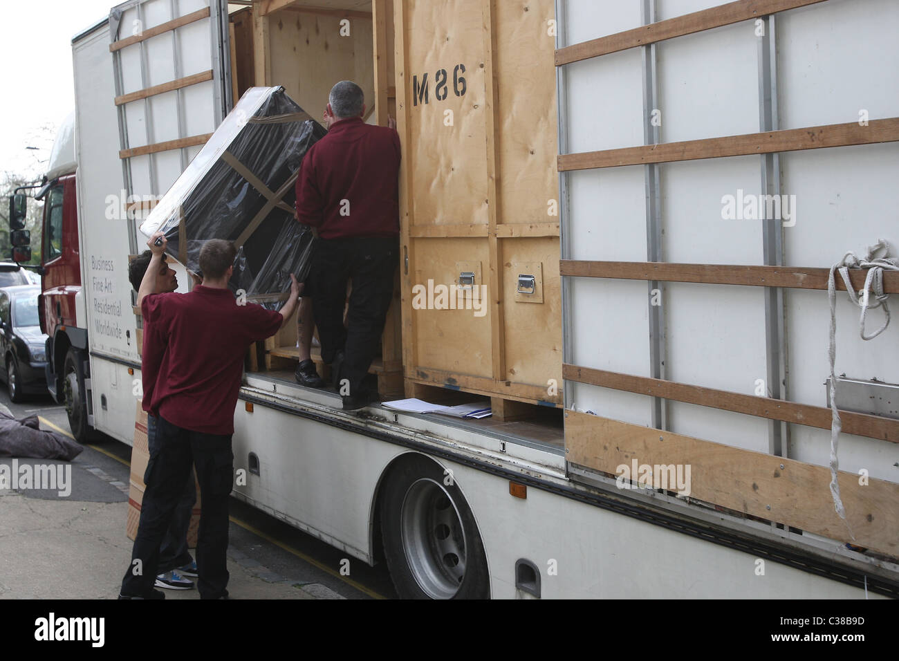 Movers are seen loading boxes and furnitures into a moving truck from