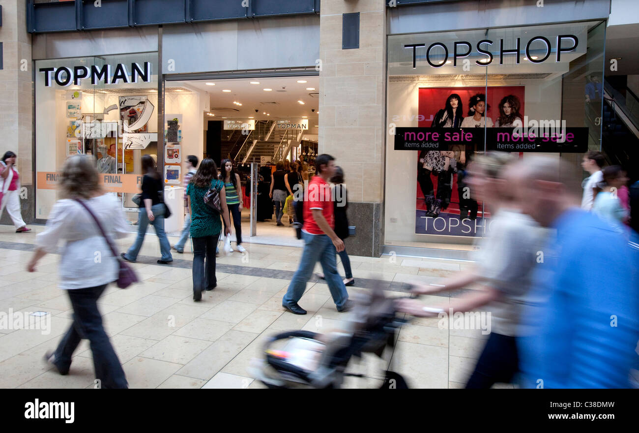 People pass in front of a branch of Topshop/Topman, Cambridge. Part of the  Arcadia Group Stock Photo - Alamy
