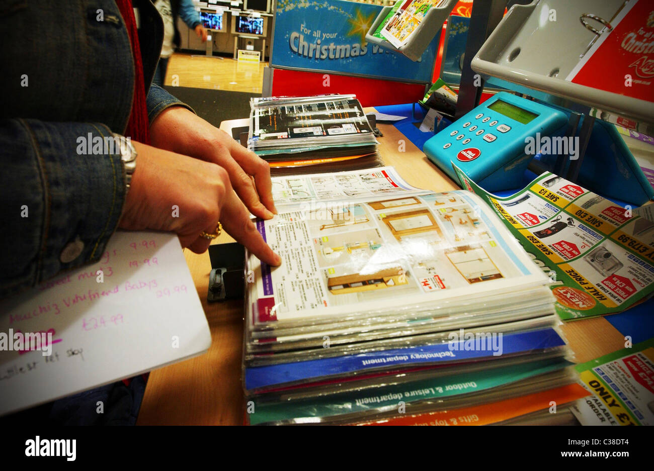 A woman checking the product description in an Argos catalog Stock Photo Alamy