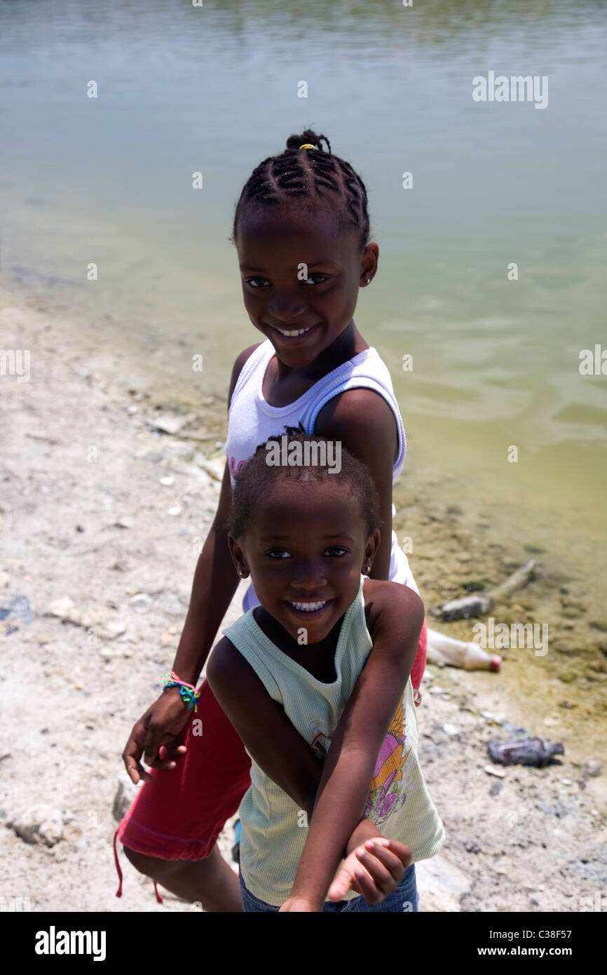 Two young sisters pose for pictures at McKinnons Pond in Antigua Stock Photo