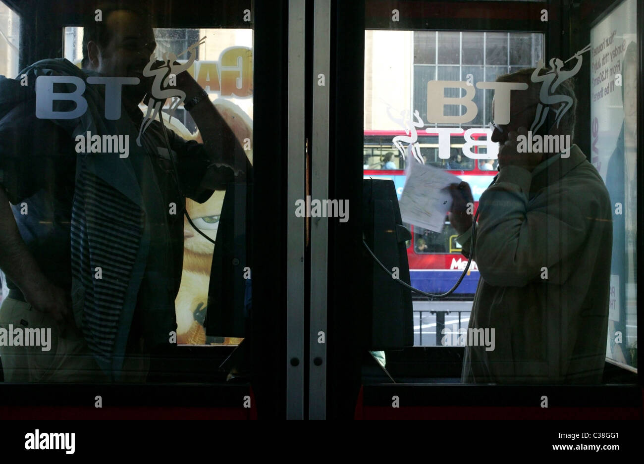 Two men using BT phone boxes in Central London. Stock Photo