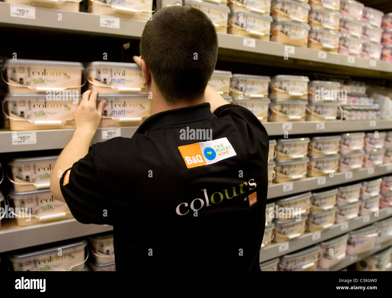 A member of staff at B&Q restoking the Colours paint stelf at a B&Q ...