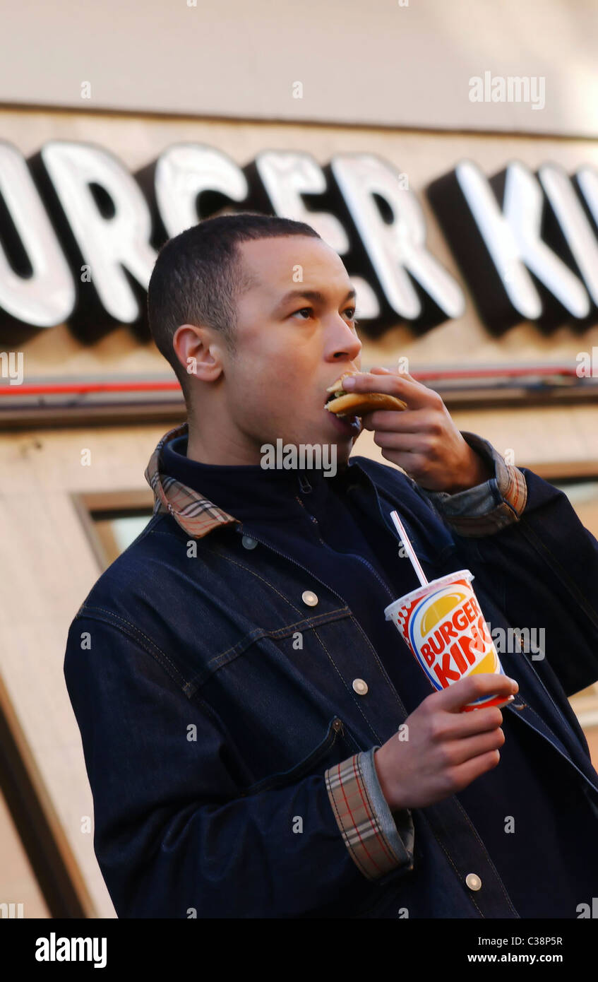 A Burger King customer eating his burger Stock Photo Alamy