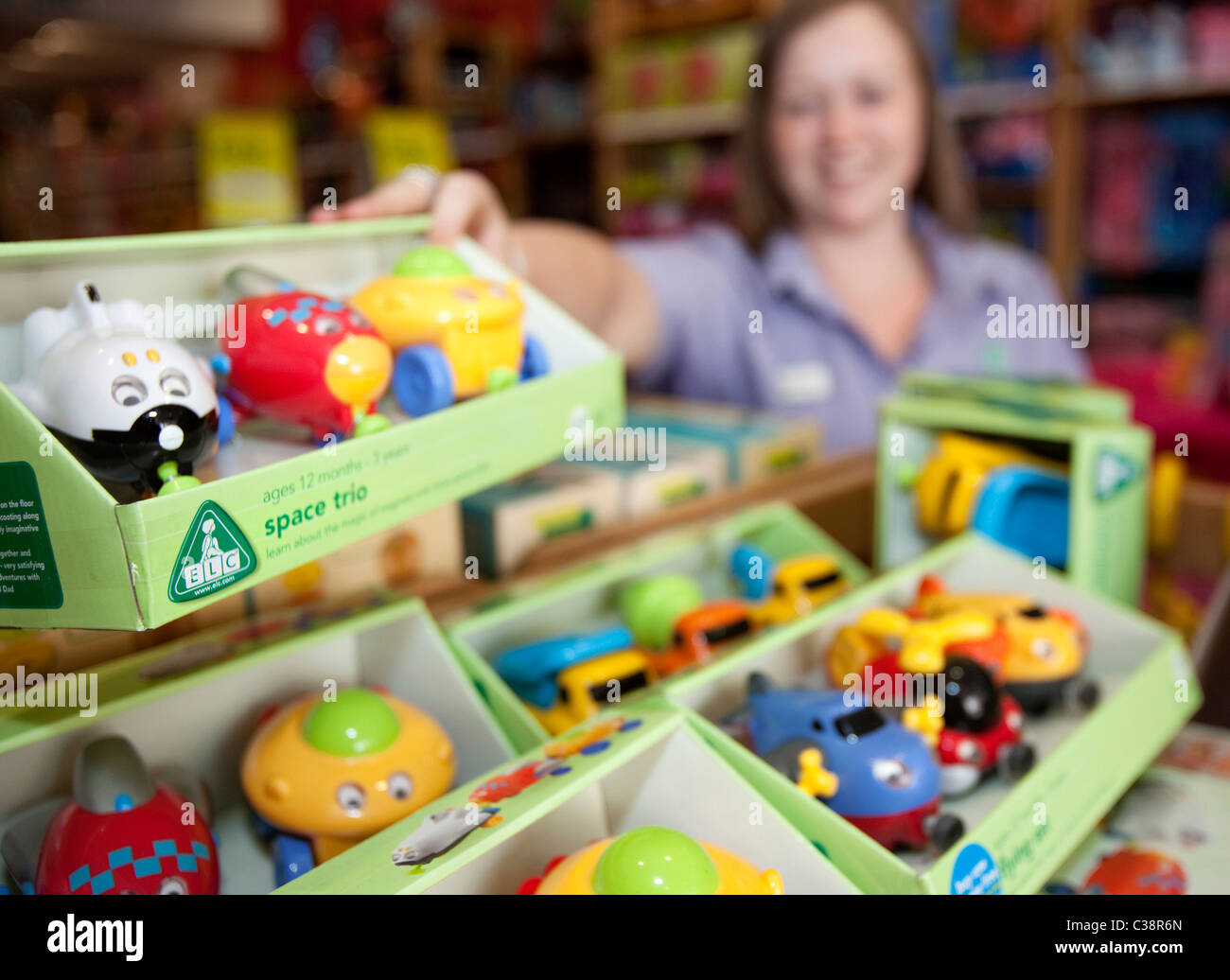 An Early Learning Centre employee tidies shelves on the shop floor, Kensington, London. Stock Photo