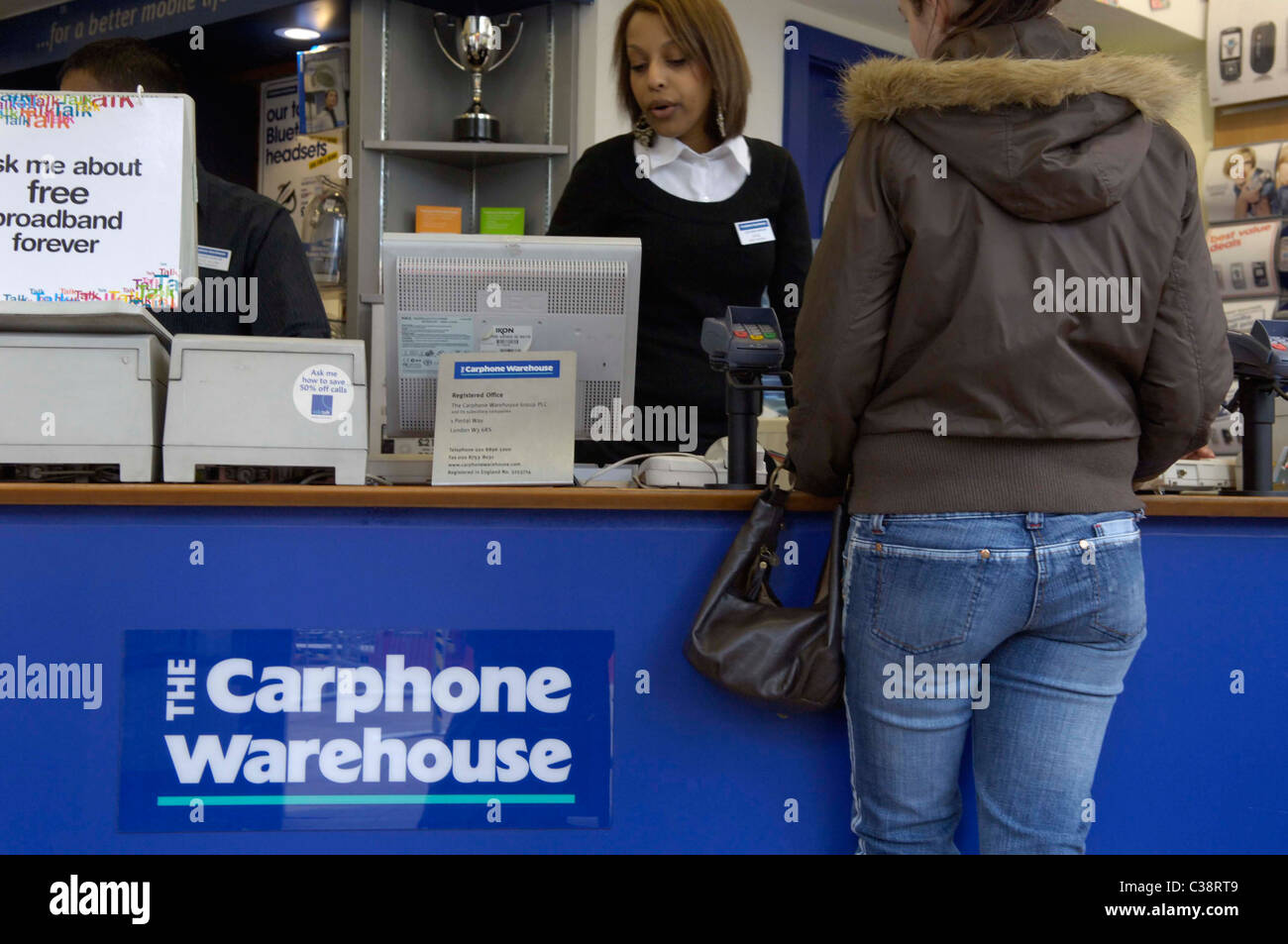 A Carphone Warehouse employee serving a customer at an in store till point. Stock Photo