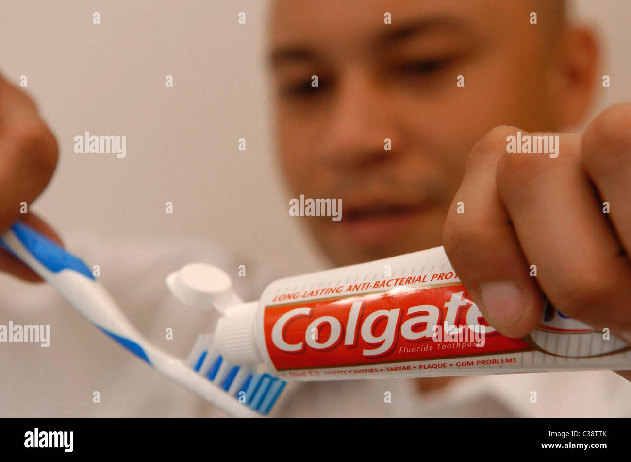 A tube of Colgate toothpaste being used in a bathroom Stock Photo Alamy